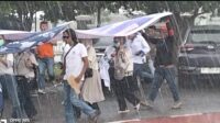 Para Pendemo berlarian menghindari hujan lebat saat melakukan orasinya di depan kantor Pemko Batam