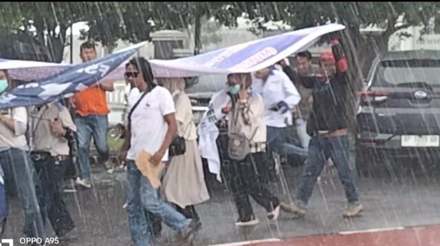 Para Pendemo berlarian menghindari hujan lebat saat melakukan orasinya di depan kantor Pemko Batam