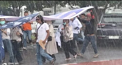 Para Pendemo berlarian menghindari hujan lebat saat melakukan orasinya di depan kantor Pemko Batam
